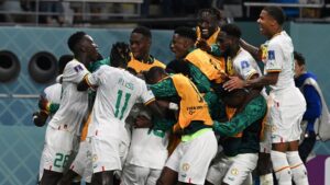 Senegal players mob Ismaila Sarr after he gives them the lead against Ecuador